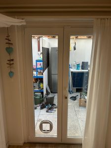Cat door fitted into a white-framed glass door