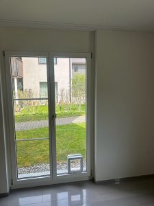 Cat door fitted into a glazed door beside a radiator